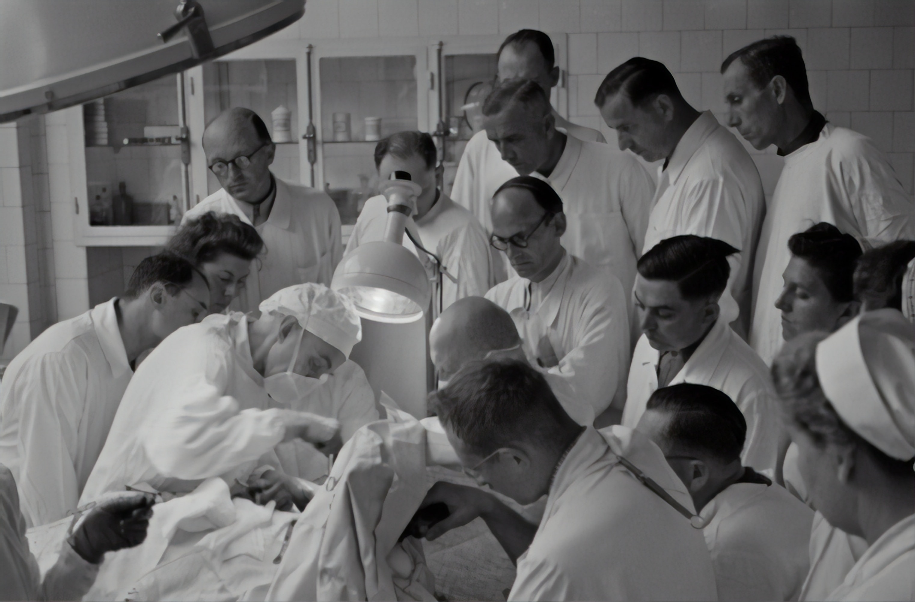 A surgeon being watched by a crowd of people